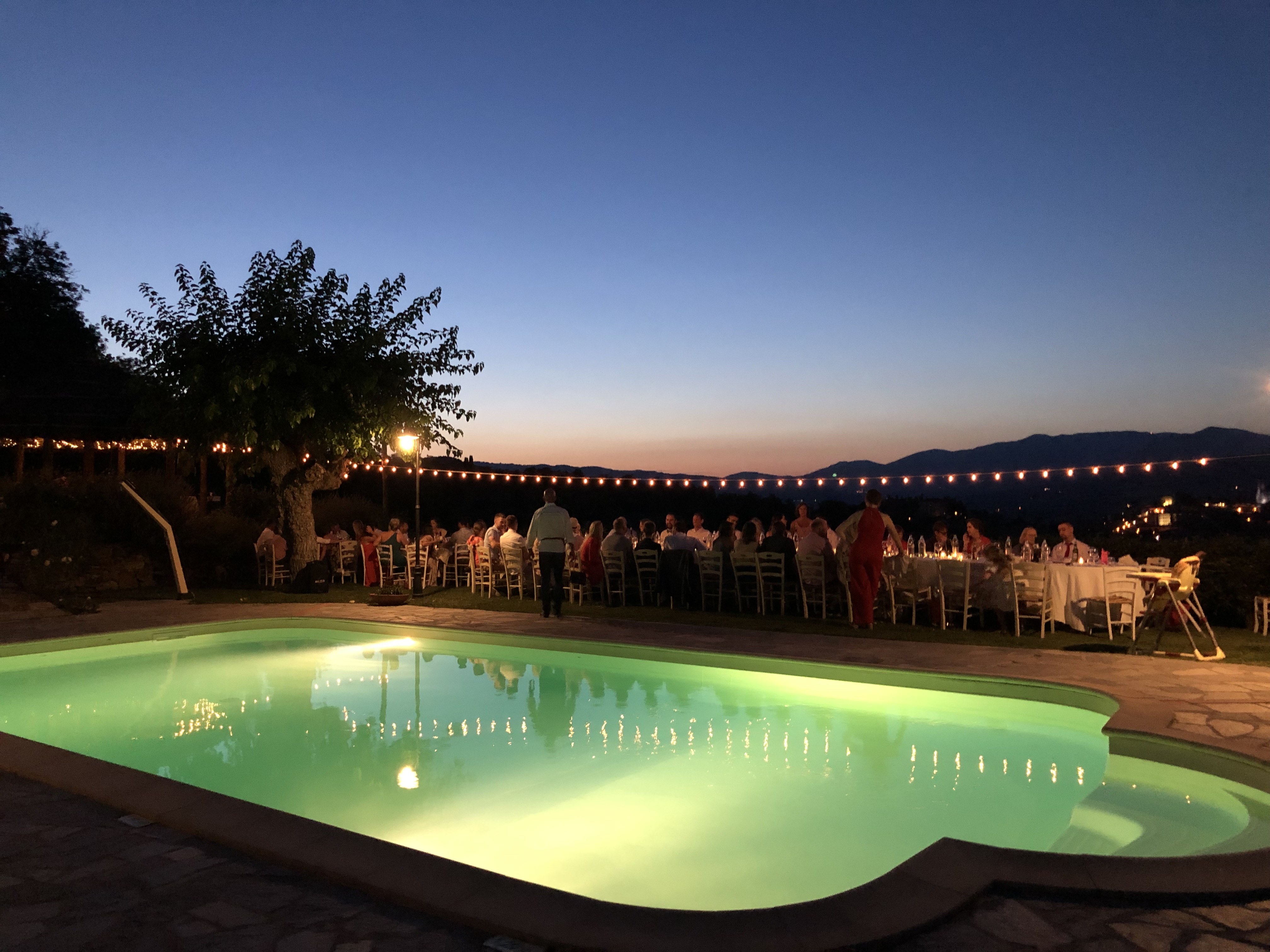 Evening poolside dinner scene used to reinforce the premium positioning around pricing and presentation.